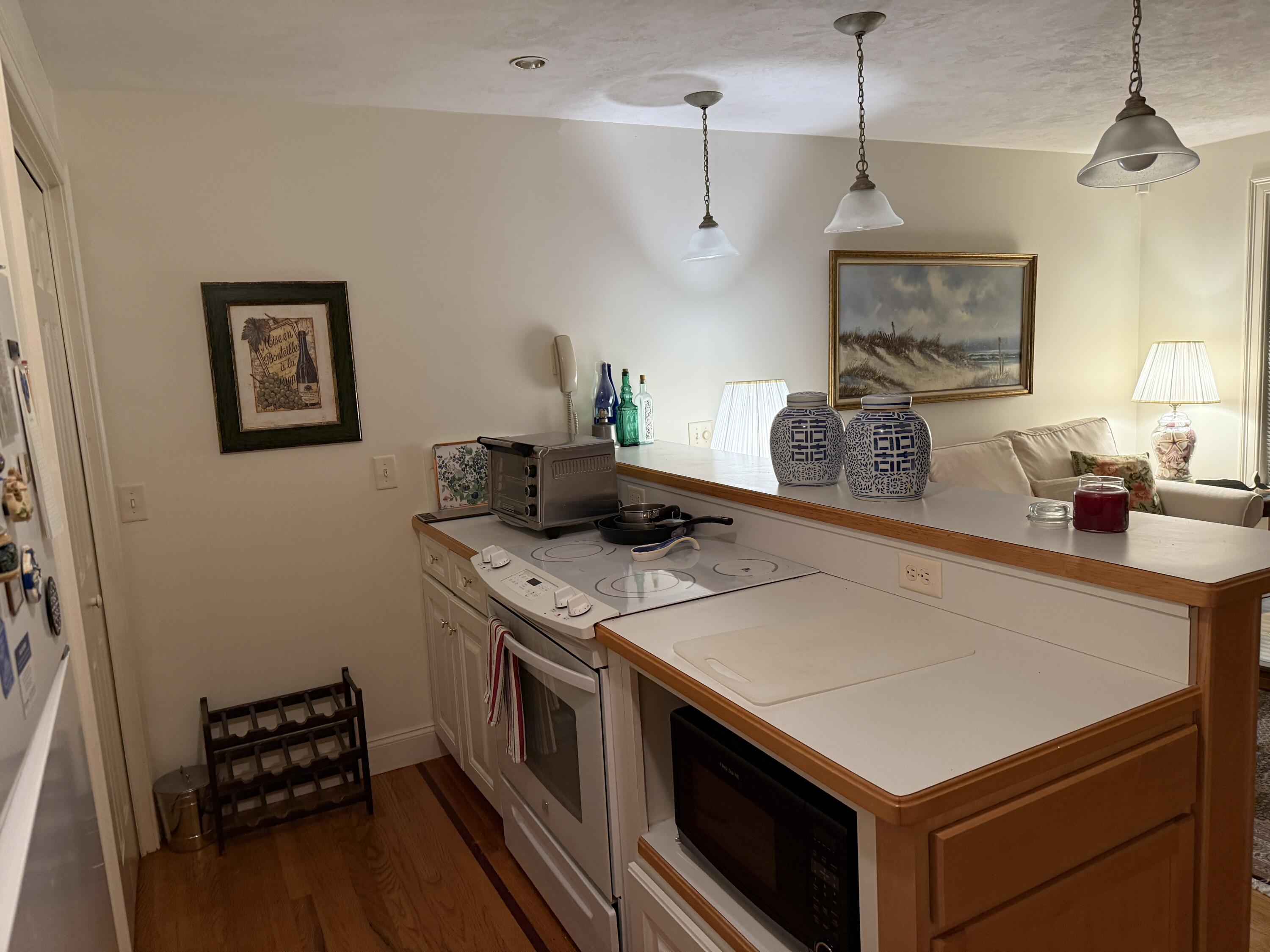 403 Lower County Road, Unit A Harwich Port, MA 02646 - Photo 5 of 12 a kitchen that has a sink a stove and a wooden floor