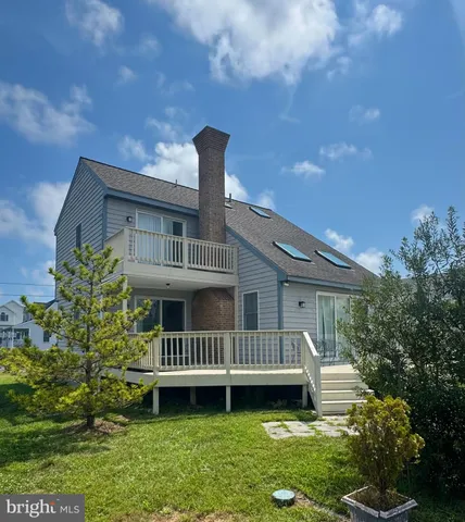 a view of a house with a deck and a yard