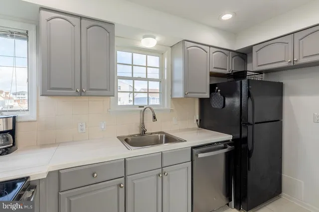 a kitchen with stainless steel appliances granite countertop a sink refrigerator and cabinets
