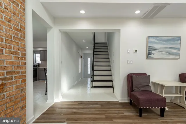 a view of a hallway with furniture and wooden floor