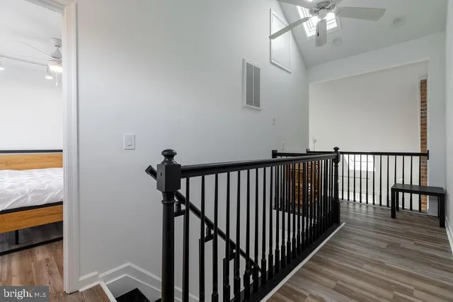 a view of a hallway with wooden floor and staircase