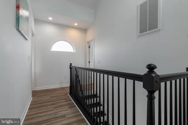 a view of a hallway with wooden floor and entryway