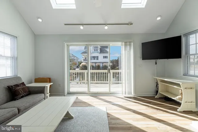 a living room with furniture a flat screen tv and a large window