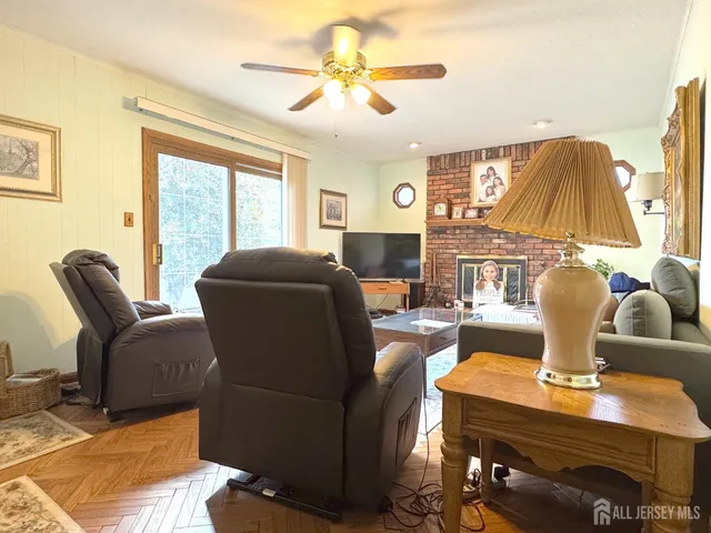 a living room with furniture a large window and a chandelier