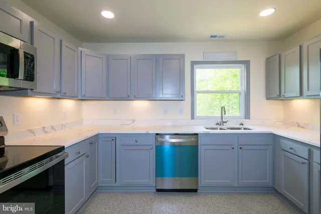 a large kitchen with a stove a sink and a refrigerator