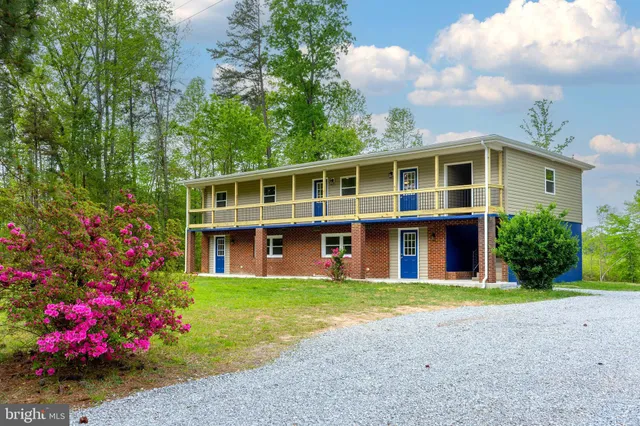 a front view of a house with a yard and fountain in middle