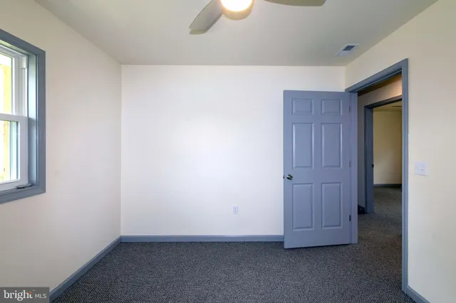 an empty room with window and wooden floor