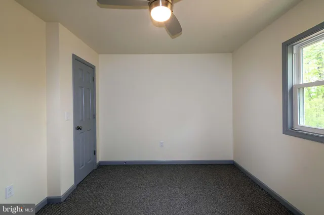 an empty room with windows and closet