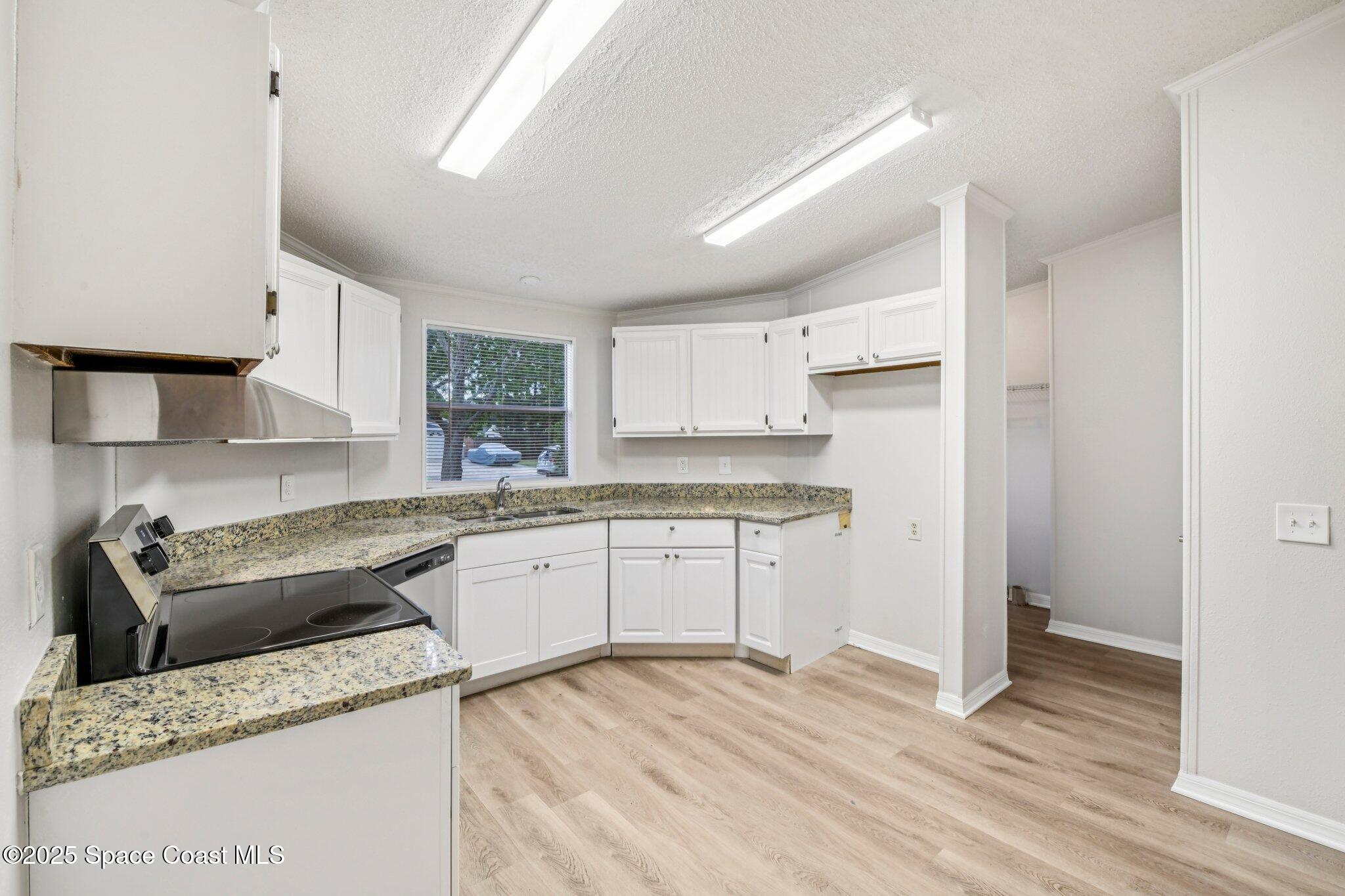 7070 Bismark Road Cocoa, FL 32927 - Photo 14 of 38 a kitchen with granite countertop cabinets stainless steel appliances a sink and a window