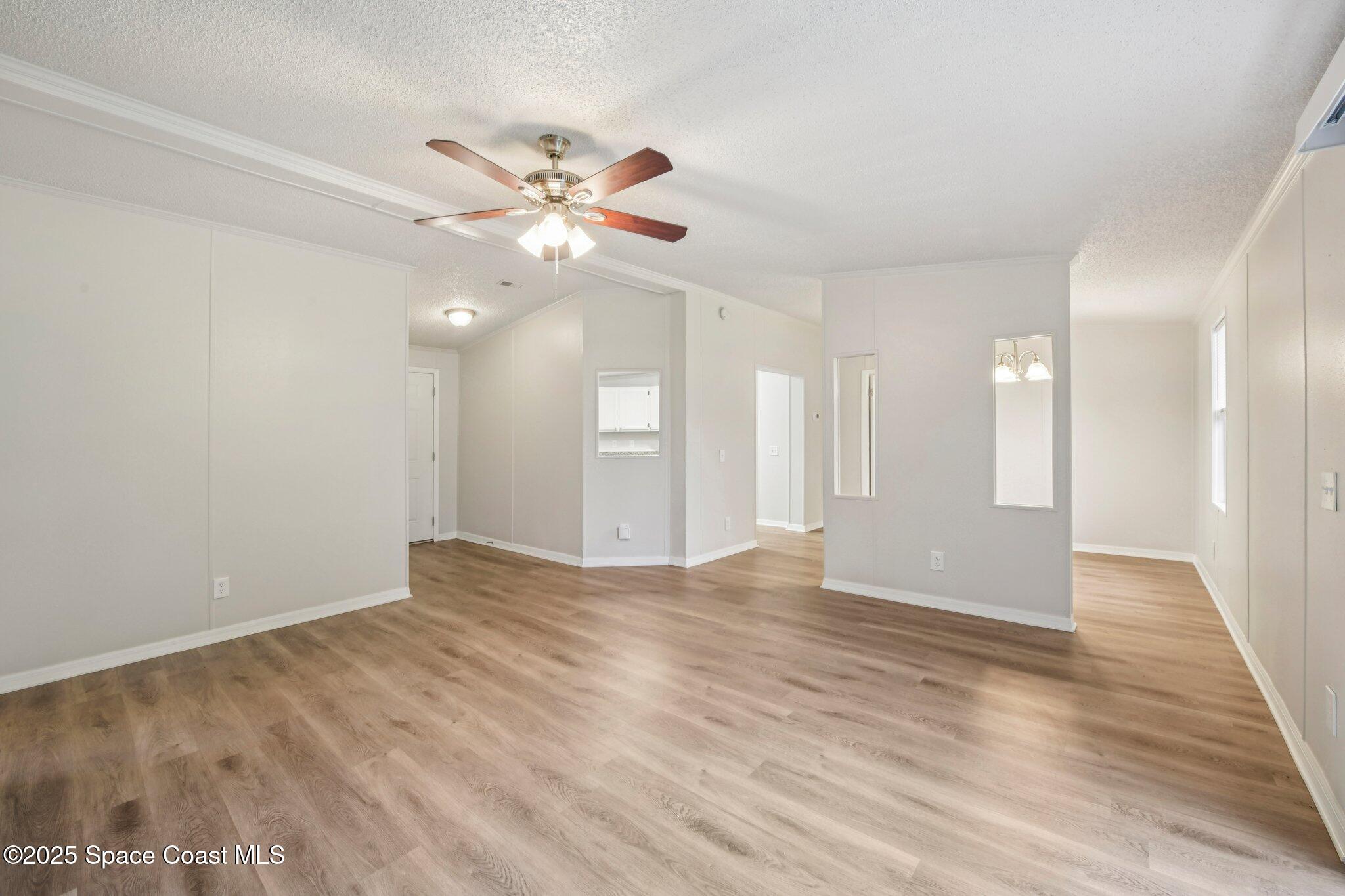 7070 Bismark Road Cocoa, FL 32927 - Photo 20 of 38 a view of an empty room with chandelier fan and wooden floor