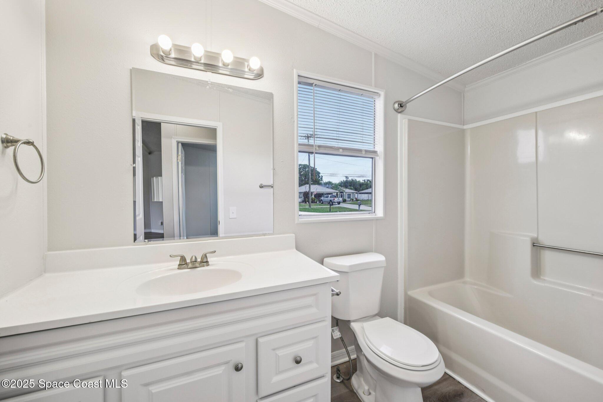 7070 Bismark Road Cocoa, FL 32927 - Photo 23 of 38 a bathroom with a sink a toilet a mirror and shower