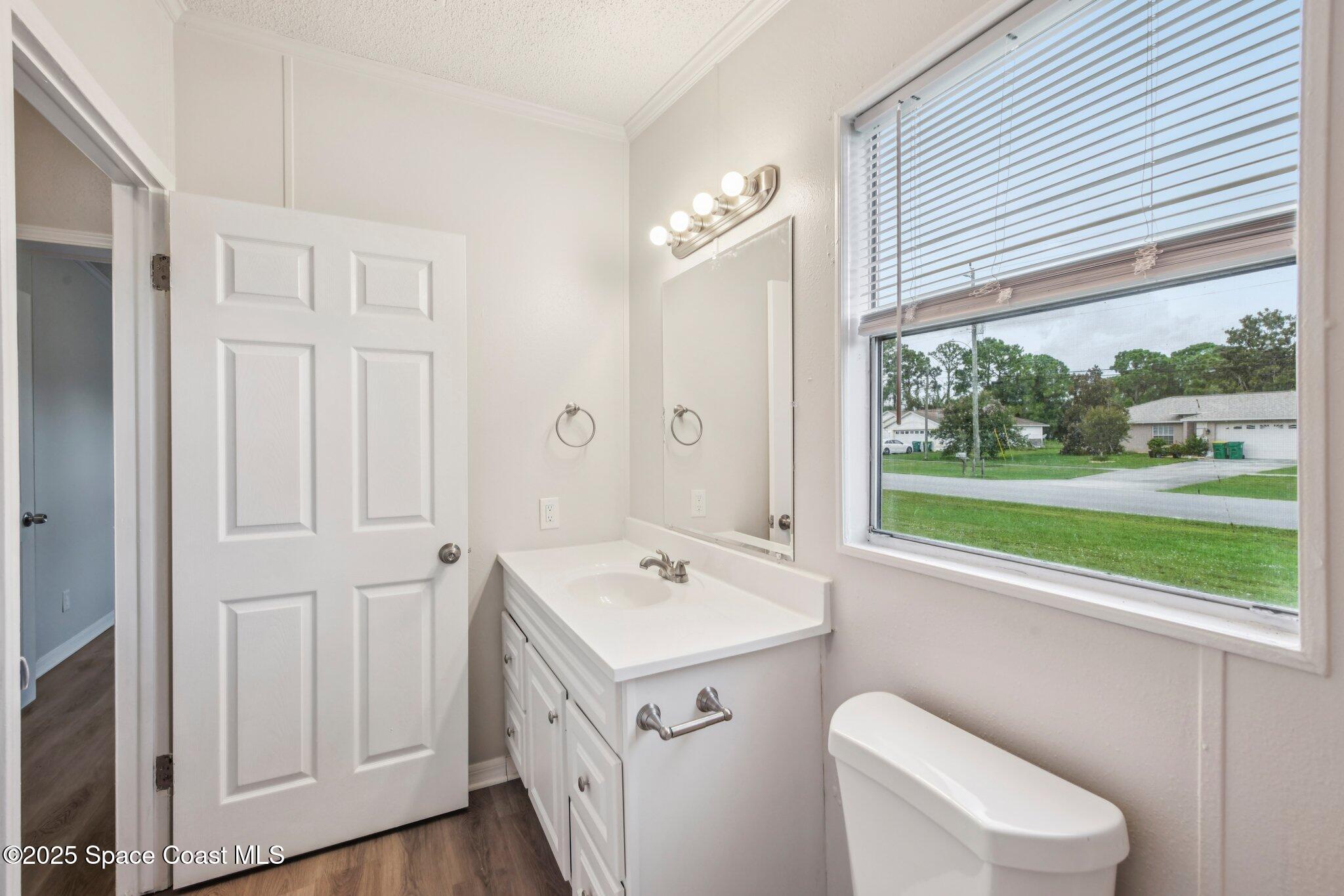 7070 Bismark Road Cocoa, FL 32927 - Photo 23 of 33 a bathroom with a sink a toilet and a window