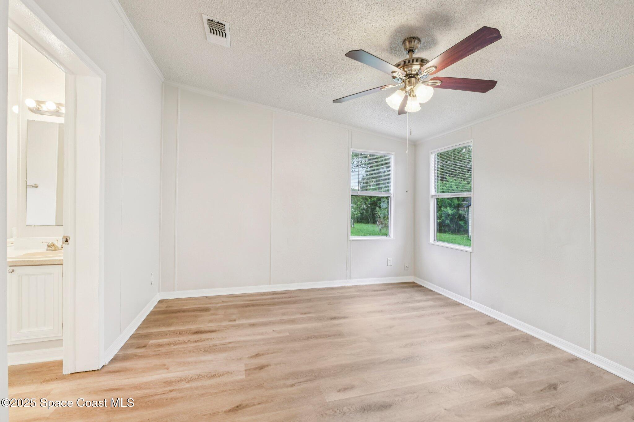 7070 Bismark Road Cocoa, FL 32927 - Photo 28 of 38 a view of an empty room with wooden floor and a window