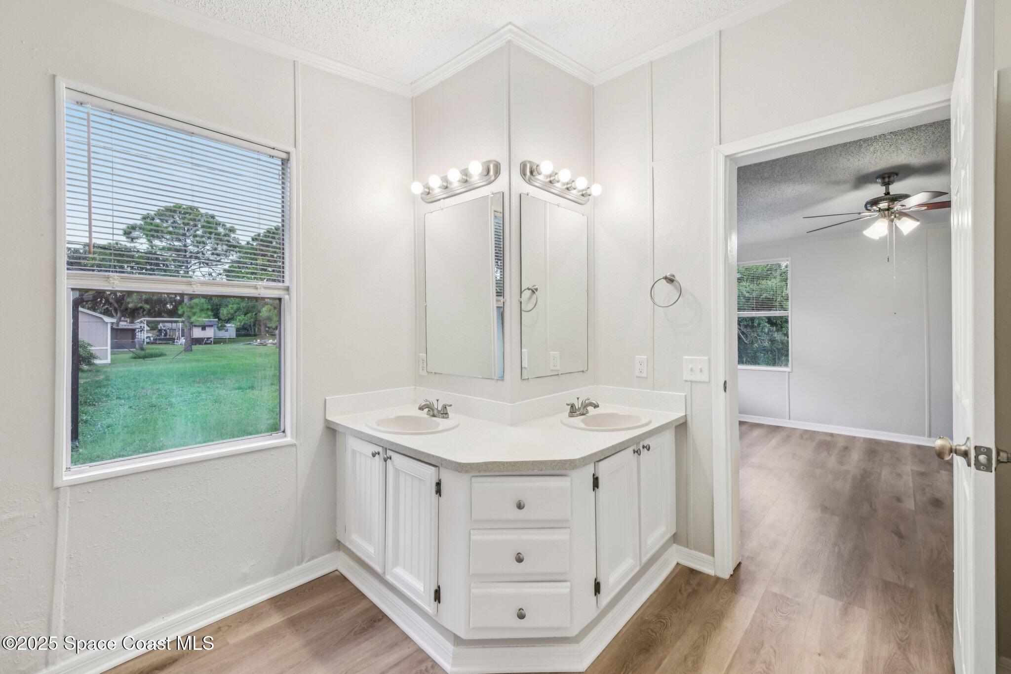 7070 Bismark Road Cocoa, FL 32927 - Photo 31 of 38 a bathroom with a double vanity sink a mirror and a bathtub