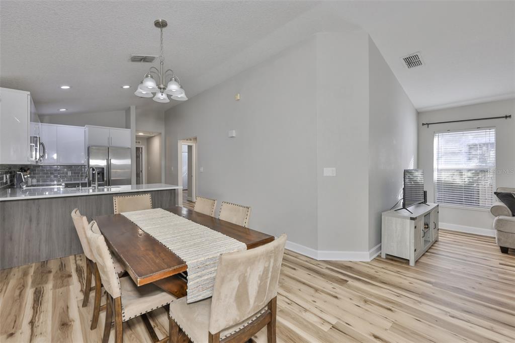 2331 West Chestnut Street Tampa, FL 33607 - Photo 6 of 33 a view of a dining room with furniture a chandelier and wooden floor