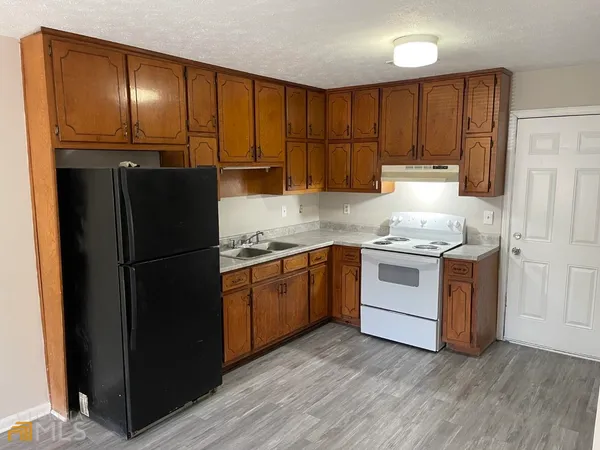 a kitchen with a refrigerator sink and cabinets