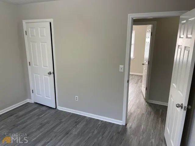 an empty room with wooden floor and entrance
