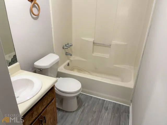 a white toilet sitting next to a bath tub