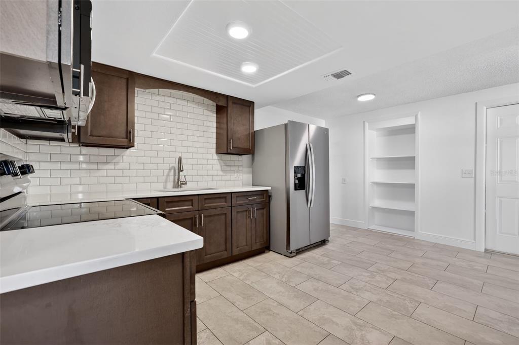 10914 Leeds Road Port Richey, FL 34668 - Photo 7 of 24 a kitchen with stainless steel appliances a refrigerator and a sink