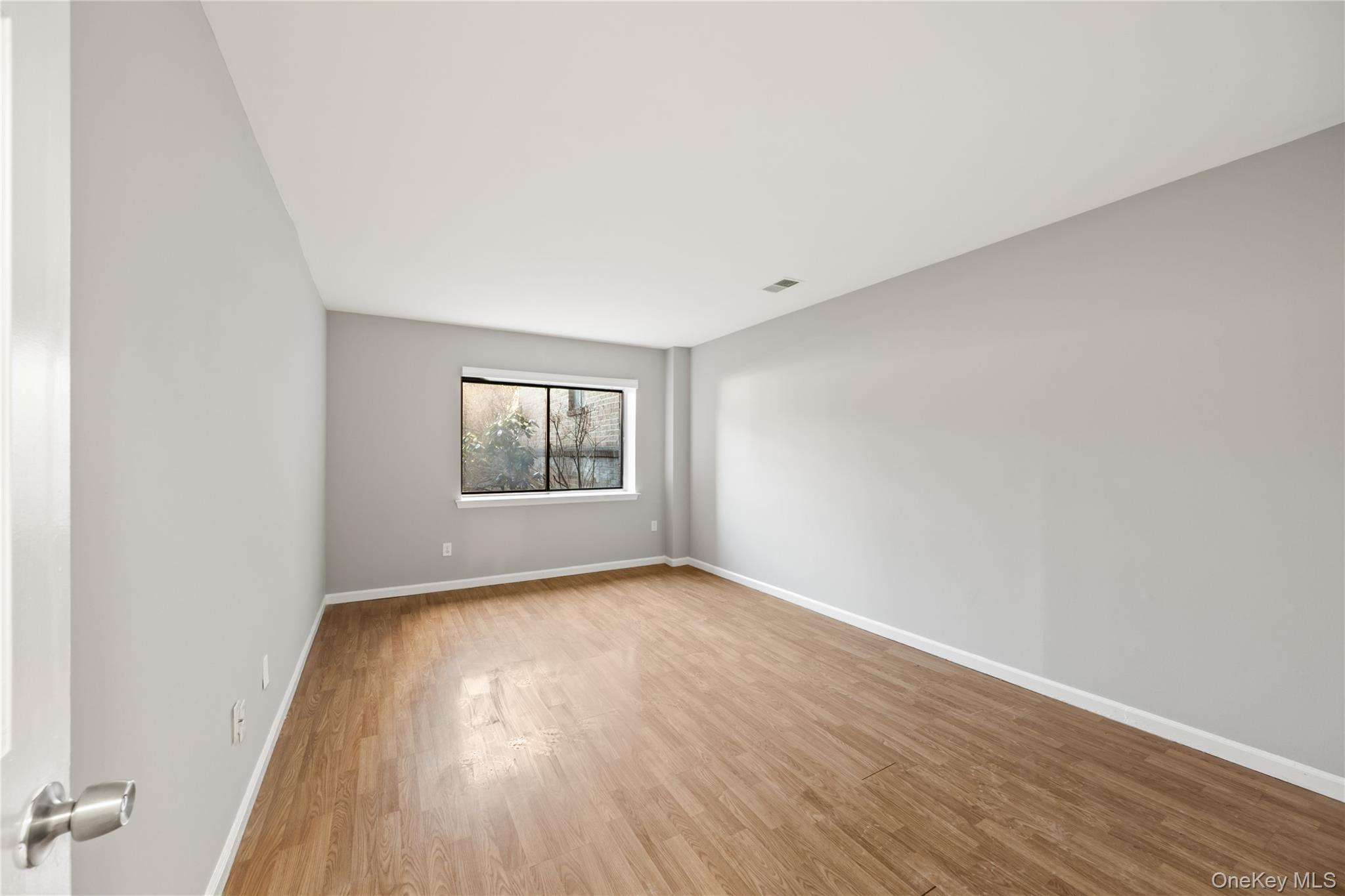 402 Kennedy Drive Spring Valley, NY 10977 - Photo 13 of 26 an empty room with wooden floor and windows