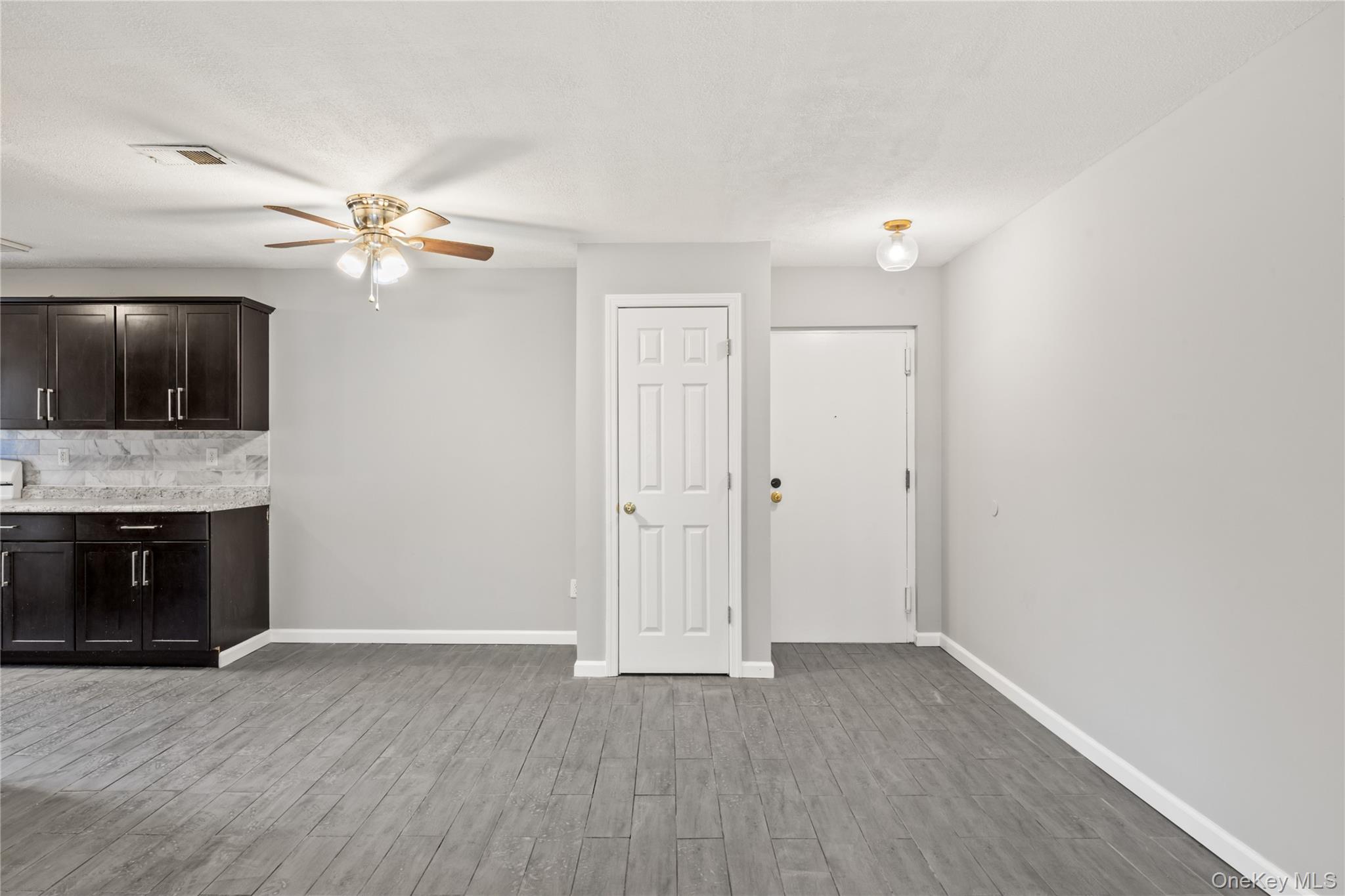 402 Kennedy Drive Spring Valley, NY 10977 - Photo 4 of 26 a view of a livingroom with a fireplace a ceiling fan and wooden floor