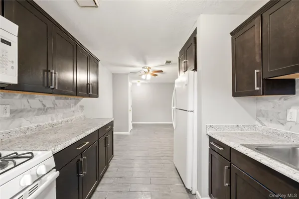 a kitchen with granite countertop a refrigerator and a sink