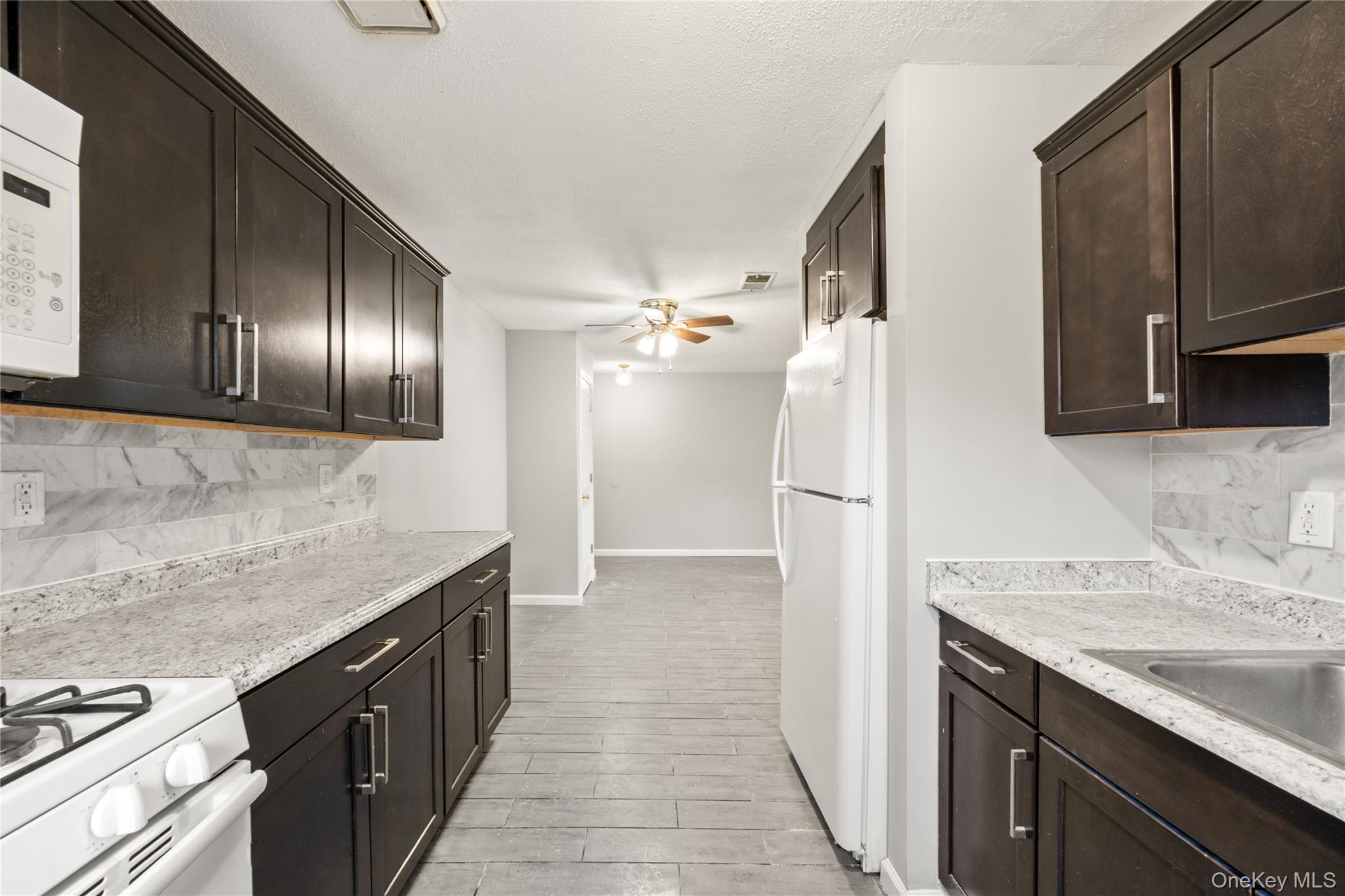 402 Kennedy Drive Spring Valley, NY 10977 - Photo 7 of 26 a kitchen with granite countertop stainless steel appliances a sink stove and refrigerator