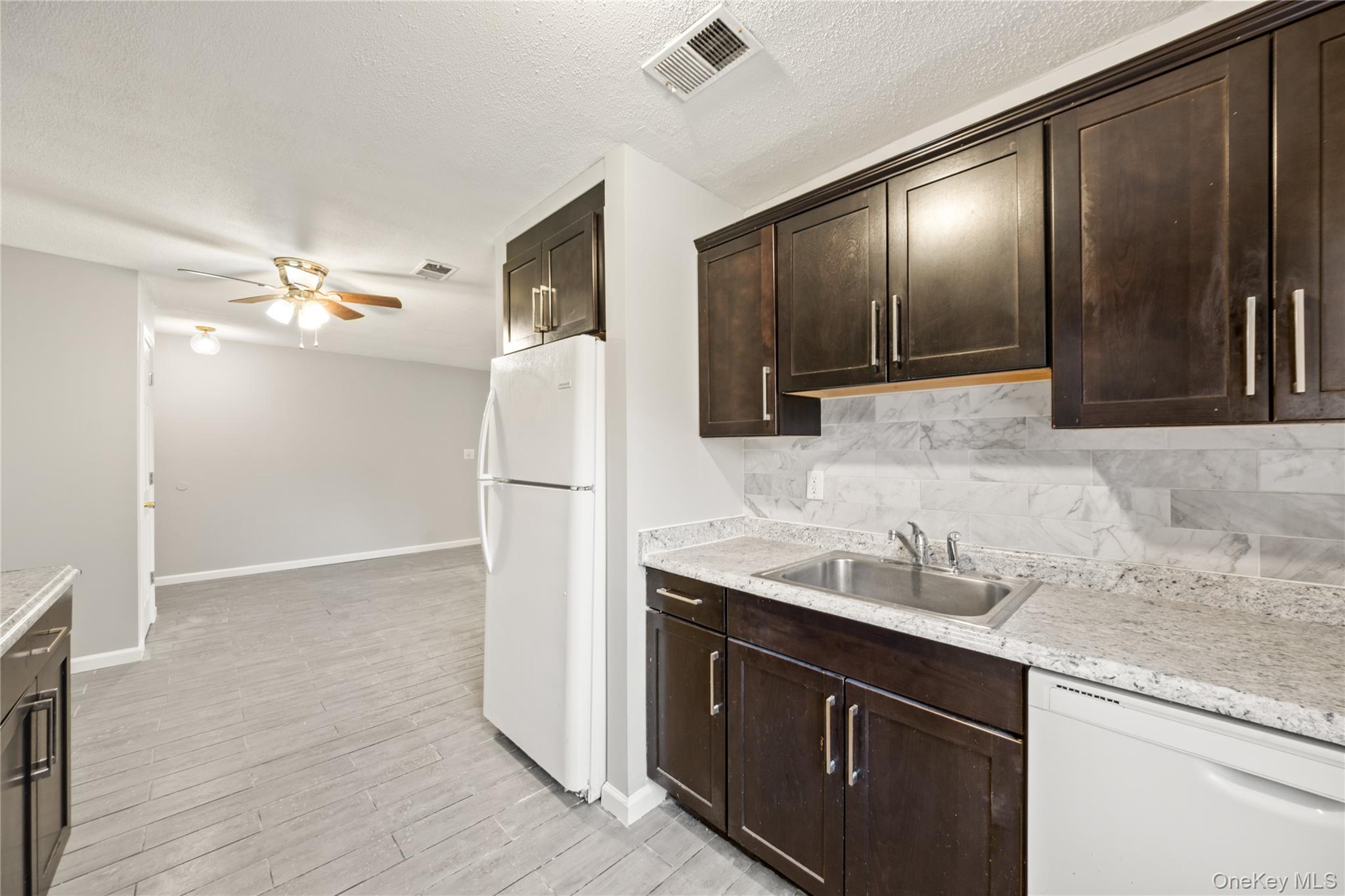 402 Kennedy Drive Spring Valley, NY 10977 - Photo 8 of 26 a kitchen with granite countertop a refrigerator and a sink