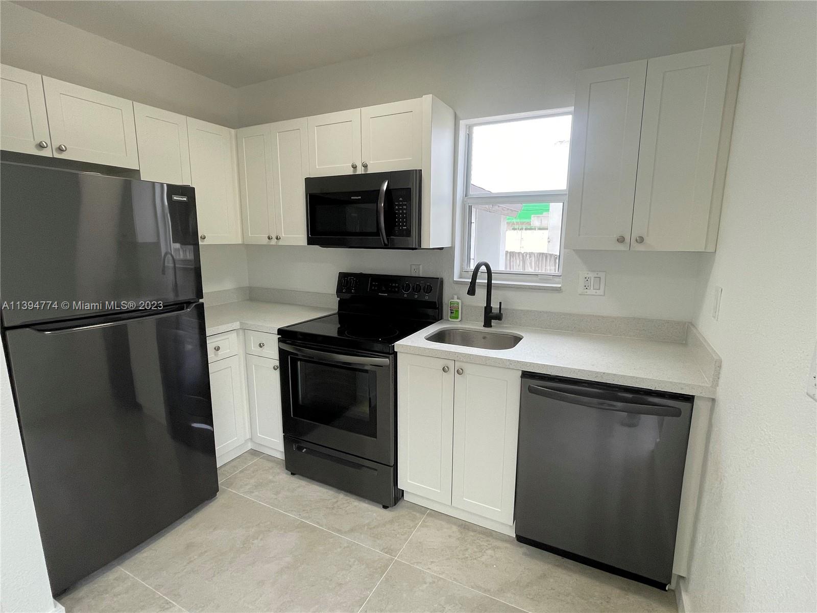 2607 Northwest 29th Street Miami, FL 33142 - Photo 2 of 13 a kitchen with a sink stove and refrigerator
