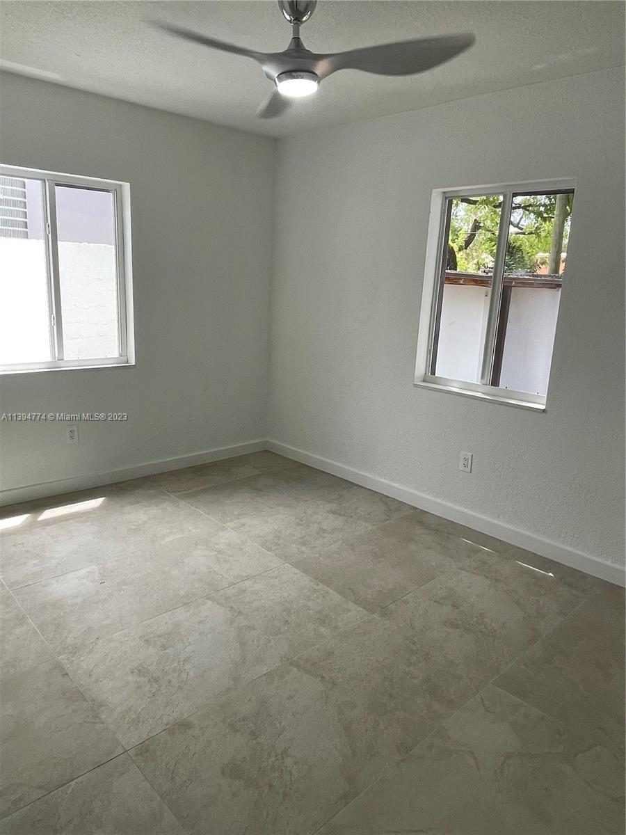 2607 Northwest 29th Street Miami, FL 33142 - Photo 3 of 13 an empty room with windows and fan