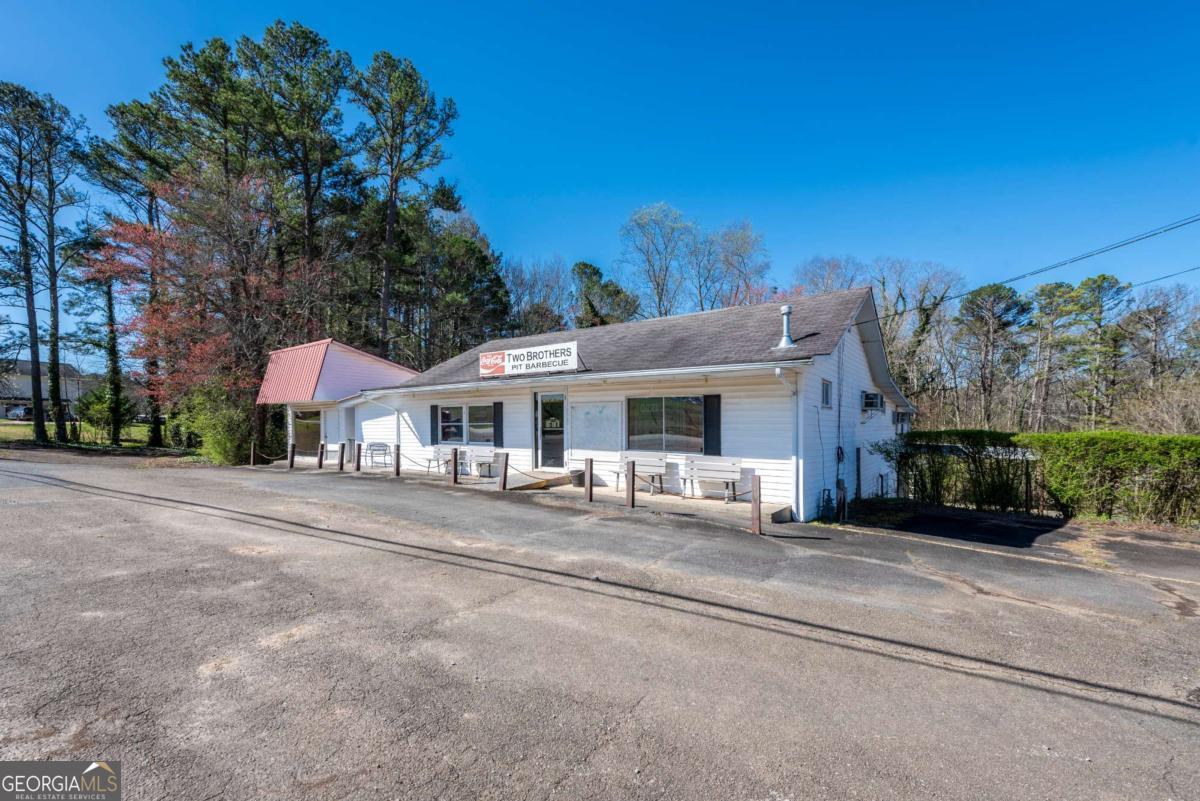 1695 Old Canton Road Ball Ground, GA 30107 - Photo 1 of 43 a view of a house with a yard and large trees
