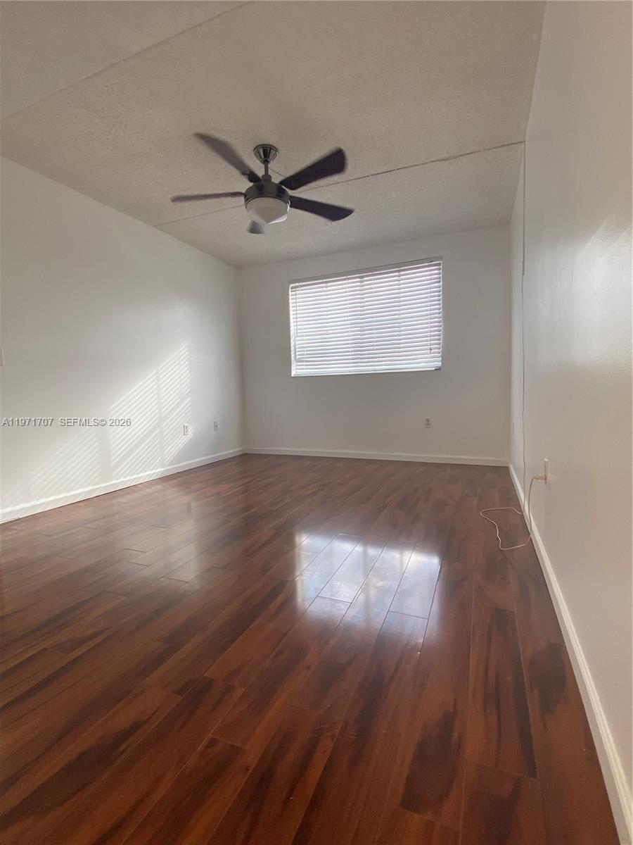 6155 Northwest 186th Street, Unit 308 Hialeah, FL 33015 - Photo 16 of 34 an empty room with wooden floor windows and fan