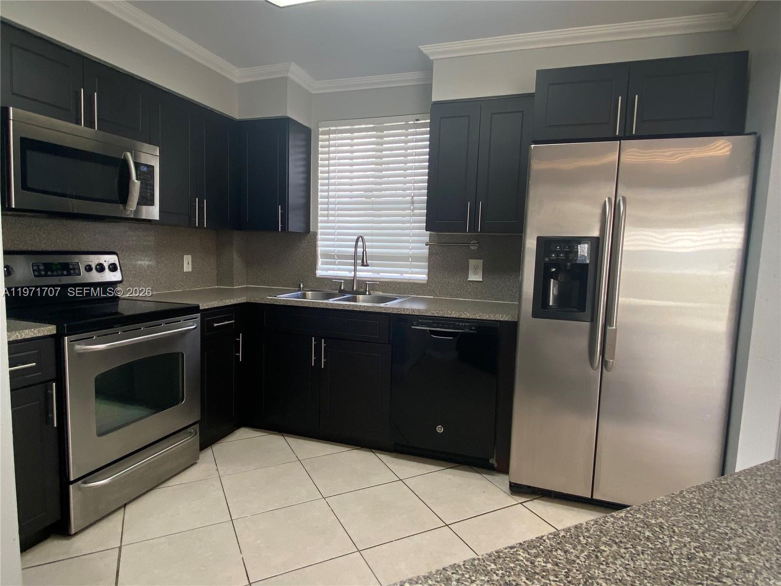 6155 Northwest 186th Street, Unit 308 Hialeah, FL 33015 - Photo 4 of 34 a kitchen with a refrigerator sink and microwave