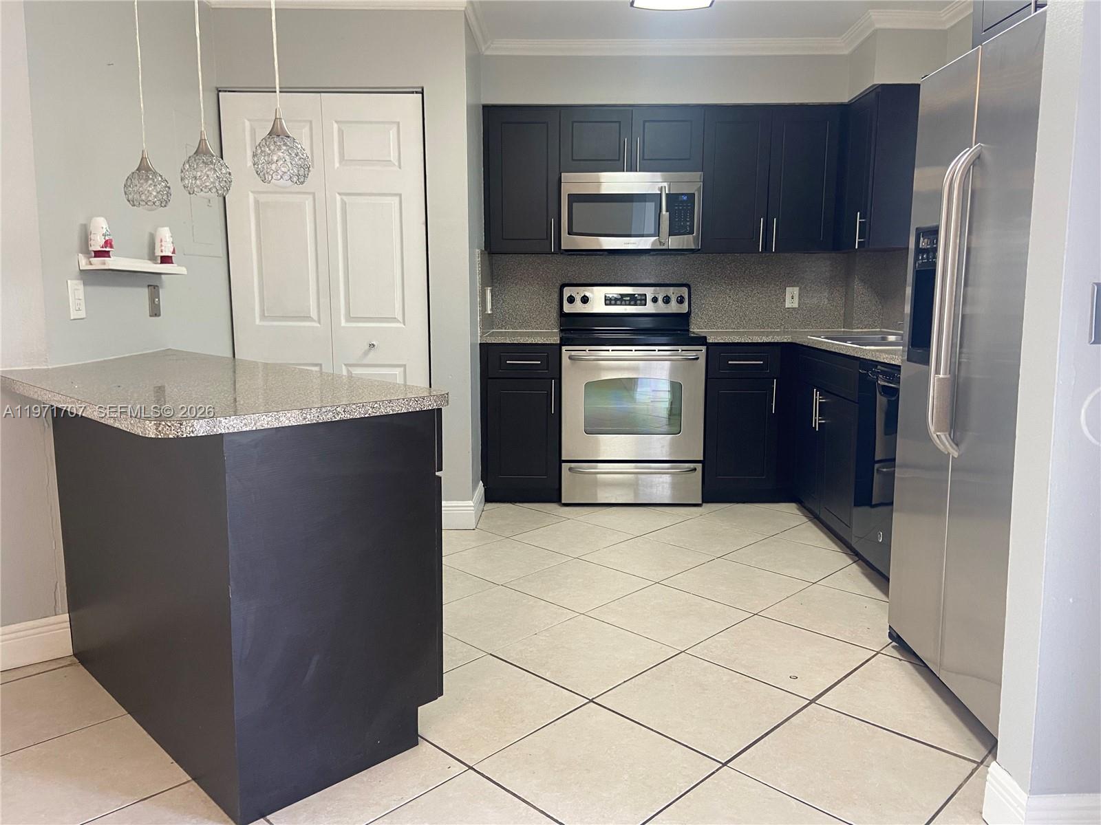 6155 Northwest 186th Street, Unit 308 Hialeah, FL 33015 - Photo 5 of 34 a kitchen with stainless steel appliances granite countertop a refrigerator and a stove