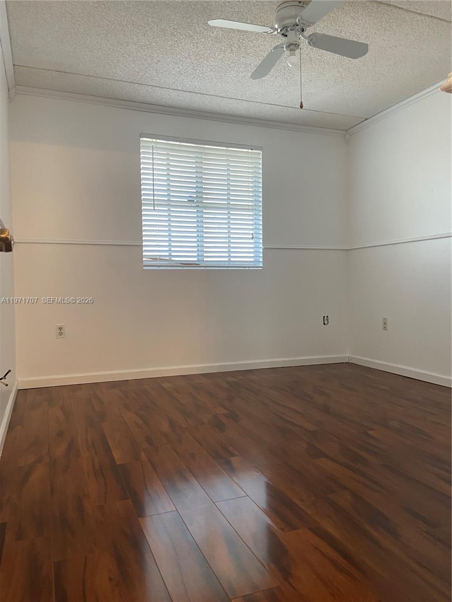 6155 Northwest 186th Street, Unit 308 Hialeah, FL 33015 - Photo 9 of 34 an empty room with wooden floor fan and windows