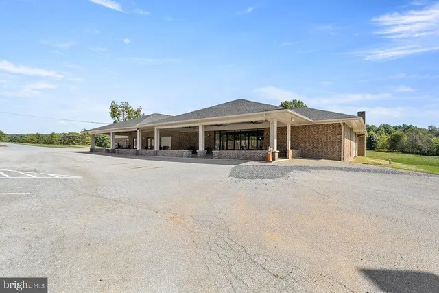 a front view of a house with a yard and palm trees
