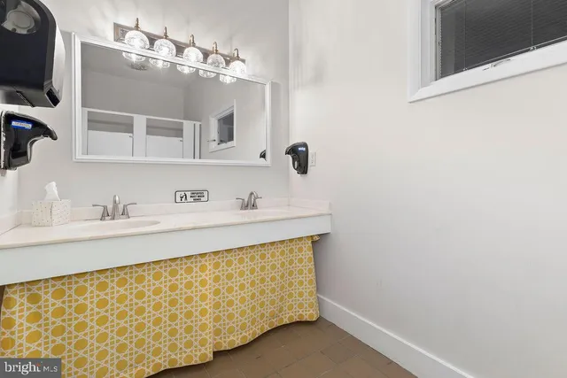 a bathroom with a sink a toilet and mirror