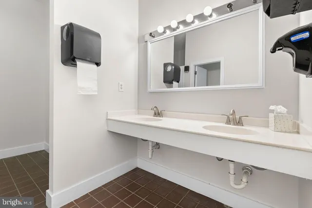 a living room with stainless steel appliances furniture a rug and a kitchen view