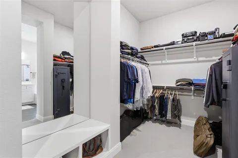 a view of walk in closet with clothes and shoes