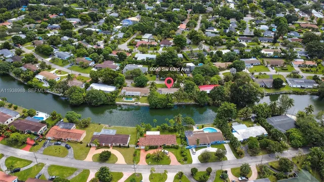 an aerial view of residential houses with outdoor space and trees all around