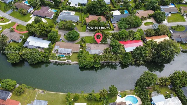 an aerial view of residential houses with outdoor space and trees