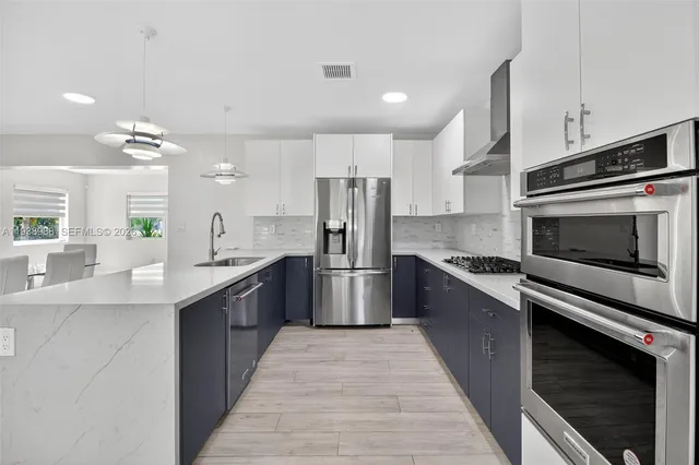 a kitchen with stainless steel appliances granite countertop a sink stove and refrigerator