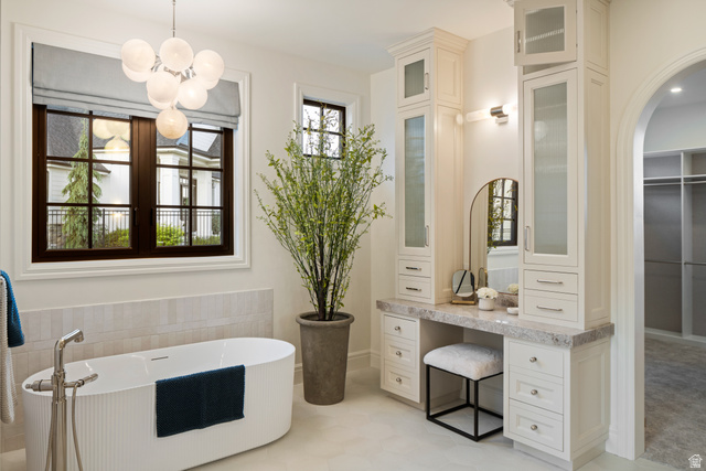 423 Eldorado Drive Mapleton, UT 84664 - Photo 20 of 40 Bathroom featuring a soaking tub, a walk in closet, tile walls, hanging lights, and light tile patterned floors