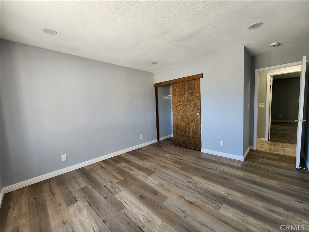28035 Bonanza Road Barstow, CA 92311 - Photo 11 of 29 a view of an empty room with wooden floor
