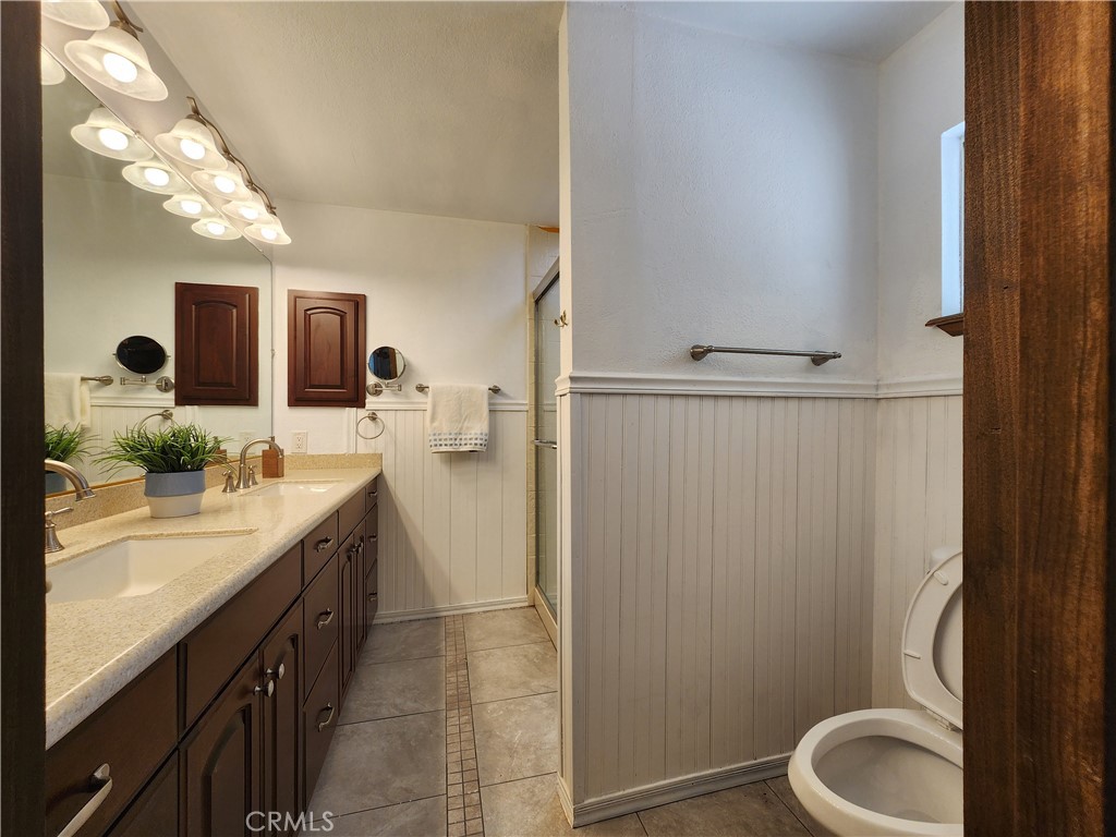 28035 Bonanza Road Barstow, CA 92311 - Photo 16 of 29 a spacious bathroom with a granite countertop sink mirror vanity and toilet