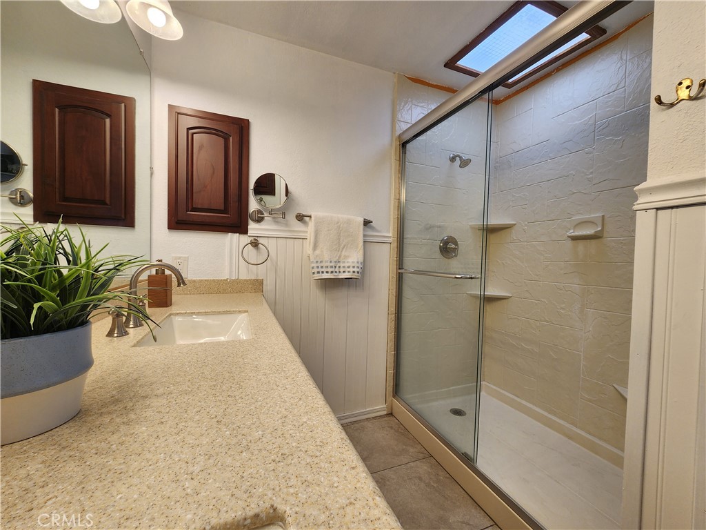 28035 Bonanza Road Barstow, CA 92311 - Photo 17 of 29 a bathroom with a tub shower and mirror