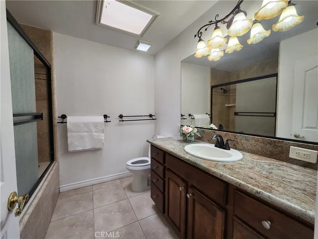 a bathroom with a granite countertop sink a toilet and a mirror