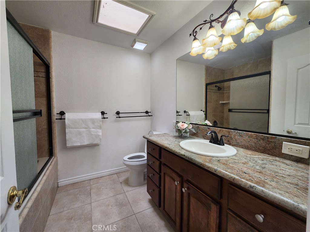 28035 Bonanza Road Barstow, CA 92311 - Photo 18 of 29 a bathroom with a granite countertop sink a toilet and a mirror
