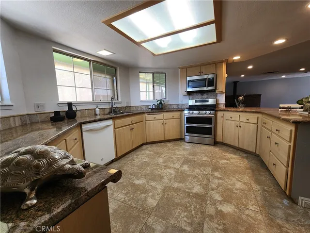 a kitchen with stainless steel appliances granite countertop a sink stove and refrigerator