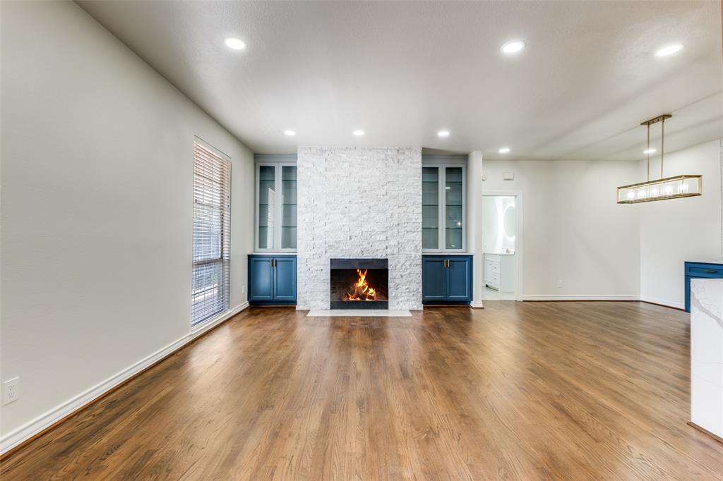3208 Cole Avenue, Unit 2202 Dallas, TX 75204 - Photo 6 of 26 an empty room with wooden floor fireplace and windows